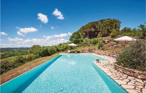 a blue swimming pool with a stone path around it at Santantimo in Castellina in Chianti