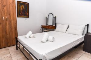 a bedroom with a large white bed with white pillows at Donna Dorato in Finikounta