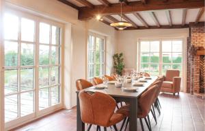 jadalnia ze stołem, krzesłami i oknami w obiekcie Nice Home In Groede With 4 Bedrooms And Wifi w mieście Groede