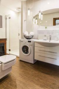 een witte badkamer met een wasmachine en een wastafel bij Apartament De Lux Cicha Woda in Zakopane