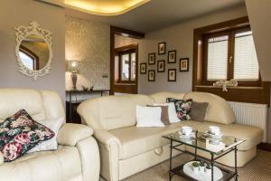 a living room with two white couches and a table at Apartament De Lux Cicha Woda in Zakopane