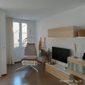 a living room with a tv and a chair at La Yeye in Port de la Selva