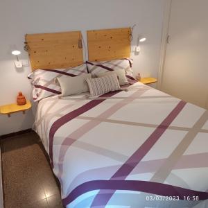 1 dormitorio con 1 cama grande y cabecero de madera en La Yeye en Port de la Selva