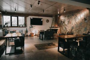 a dining room with tables and chairs and a tv at Paramount Kazbegi in Stepantsminda