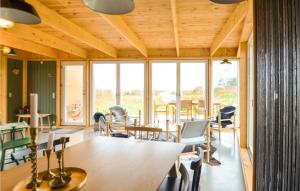 Habitación con mesa, sillas y ventanas. en Lovely Home In Ebeltoft With House Sea View, en Ebeltoft