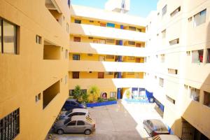 um edifício de apartamentos com carros estacionados num parque de estacionamento em Hermoso y cómodo apartaestudio! em Barranquilla
