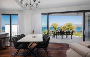 - un salon avec une table et des chaises et une vue sur l'océan dans l'établissement Gorgeous Home In Zidarici With Kitchen, à Vantačići