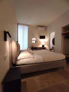 a bedroom with a bed with a chair and a window at La Maison in Trani