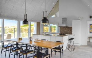 uma cozinha com uma grande mesa de madeira e cadeiras em Gorgeous Home In Ringkbing With House A Panoramic View em Ringkøbing