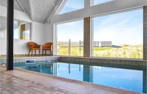 uma piscina interior com vista para uma casa em Gorgeous Home In Ringkbing With House A Panoramic View em Ringkøbing