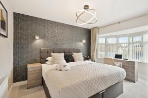 a bedroom with a large bed and a desk at Luxurious 4 Bed House, Solihull, NEC, Airport, Business & Leisure Stays - Wisteria House in Solihull
