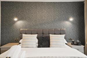 a bedroom with a large bed with a gray wall at Luxurious 4 Bed House, Solihull, NEC, Airport, Business & Leisure Stays - Wisteria House in Solihull