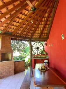 a patio with a wooden bench in a room at Hotel Chalés Gramado in Santa Bárbara do Rio Pardo