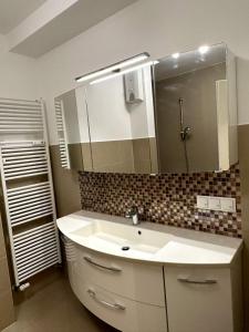 uma casa de banho com um lavatório branco e um espelho. em Willy Studio Apartment Frankfurt em Frankfurt