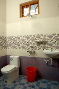 a bathroom with a toilet and a sink at THEKKADY HOMES in Thekkady