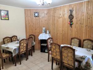 una sala da pranzo con tavoli, sedie e un orologio sul muro di Oskolok Dovbusha Mini-Hotel a Jaremče