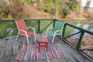 three chairs and a table on a deck next to a river at Ağva Serenita Villa in Sile
