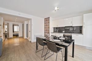 a kitchen and dining room with a table and chairs at Appartement Sauvalie - Welkeys in Le Cannet +3 photos