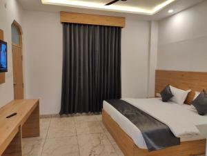 a bedroom with a bed and a television in it at Sonu Guesthouse & Hostel in Rishīkesh