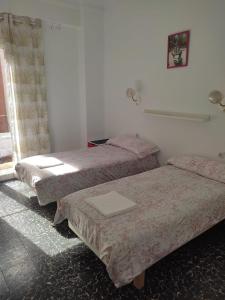 バレンシアにあるApartamento Cuatro Carreresのベッド3台と窓が備わる客室です。