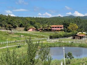 een boerderij met een wit hek en een rivier bij Haras Santa Amalia - Nova União MG in União de Caeté