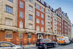 two cars parked in front of a large brick building at The Quebec Residence in London