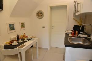 a kitchen with a sink and a table with food on it at Conte Max Rooms in Termoli