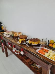 una mesa con muchos tipos diferentes de comida en ella en Pousada Girassol da Ferrugem, en Garopaba
