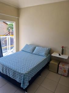 ガロパバにあるPousada Girassol da Ferrugemのベッドルーム1室(青い掛け布団、窓付)