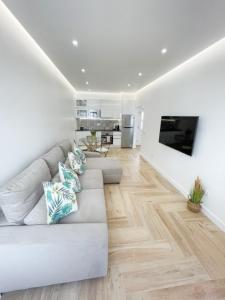 sala de estar con paredes blancas y sofá en So Sweet Center of Faro Flat, en Faro