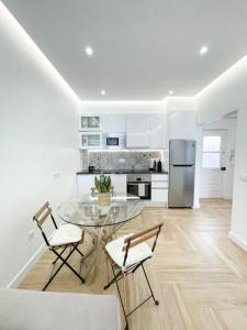 a kitchen with a glass table and two chairs at So Sweet Center of Faro Flat in Faro