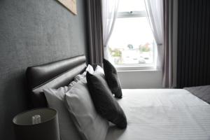 大雅茅斯的住宿－湯頓之家酒店，卧室配有带枕头的床铺和窗户。