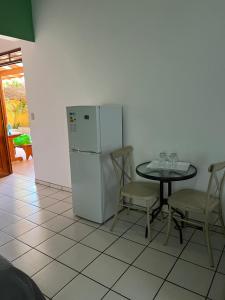 a kitchen with a table and a white refrigerator at Cabinas El Colibri in Carrillo
