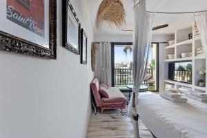 ein Schlafzimmer mit einem Bett, einem Stuhl und einem Fenster in der Unterkunft Studio Amar - Welkeys in Grimaud