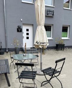 a table and chairs in front of a building at H&H Apartments im Herzen der Stadt geräumig ruhig zentral mit Küche und Esstisch in Greifswald
