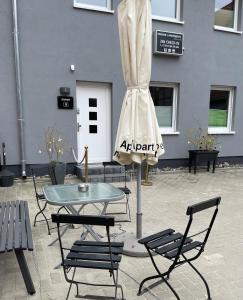 een tafel en stoelen voor een gebouw bij H&H Apartments im Herzen der Stadt geräumig ruhig zentral mit Küche und Esstisch in Greifswald