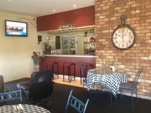 a restaurant with a table and a clock on the wall at Ceduna Motor Inn in Ceduna