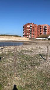 een hek in een veld naast een gebouw bij les terrasses2 in Oostende