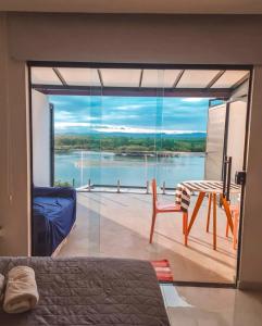 a bedroom with a view of the water at Suítes Luxo Marambaia- Epic House in Rio de Janeiro