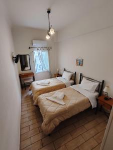 a room with three beds and a television in it at Central 9 Rooms in Ermoupoli