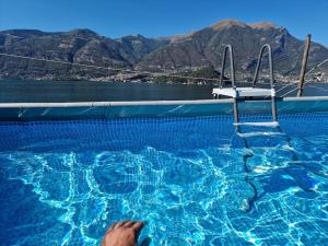 a person in a swimming pool with a chair at Mella house garden relax in Lezzeno