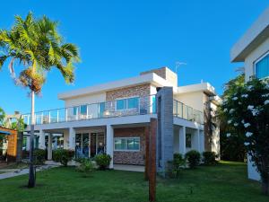 a house with a balcony and palm trees at Pousada Jirituba in Barra de Santo Antônio