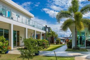 a building with a palm tree in front of it at Pousada Jirituba in Barra de Santo Antônio