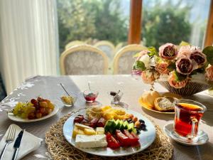 einen Tisch mit Teller mit Lebensmitteln und Blumen darauf in der Unterkunft Airport Villa hotel in Arnavutköy