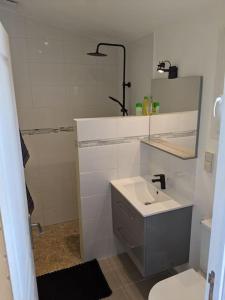 a white bathroom with a sink and a shower at Studio indépendant tout équipé au calme in Saint-Jean-Pla-de-Corts