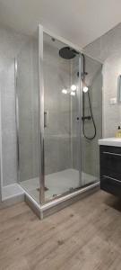 eine Dusche mit Glastür im Badezimmer in der Unterkunft Le Citadin E - Entièrement Équipé - Centre-Ville Gare in Montluçon