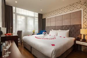 una habitación de hotel con una cama grande con un cisne. en Skyline Hanoi Hotel en Hanói