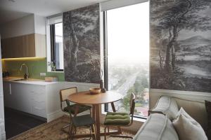 a kitchen and living room with a table and a couch at Cloud Loft Residence with 180 Degrees Views in Auckland