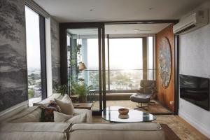 a living room with a couch and a table at Cloud Loft Residence with 180 Degrees Views in Auckland