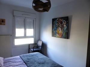 - une chambre avec un lit et une peinture murale dans l'établissement Appartement cosy 4 personnes, à Mâcon